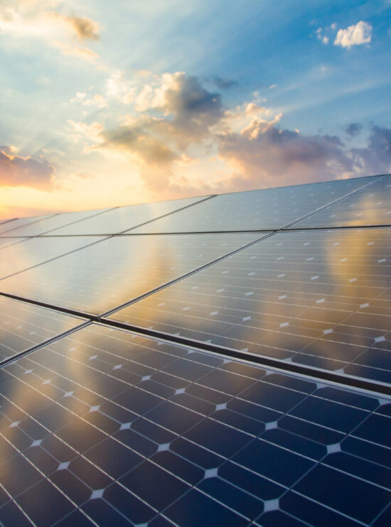 Renewable energy stock image of photovoltaic modules on the background of sunset and cloudy sky.