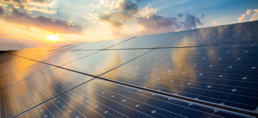 Renewable energy stock image of photovoltaic modules on the background of sunset and cloudy sky.